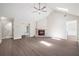 Bright living room featuring a brick fireplace, ceiling fan, vaulted ceiling, and hardwood floors at 425 Greenmont Walk Ct, Alpharetta, GA 30009