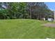Lush backyard features a large grassy area surrounded by mature trees, offering privacy and a serene outdoor space at 4401 Belcamp Rd, Union City, GA 30213