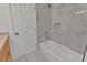 Modern bathroom features a tub with marble tile surround and in-wall storage niche at 4401 Belcamp Rd, Union City, GA 30213