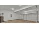 Spacious garage with a large white door, concrete floors, ample lighting, and utility connections on the wall at 4401 Belcamp Rd, Union City, GA 30213