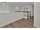 Bright hallway featuring a modern light fixture, wood-look flooring, and a staircase with white railings and dark wood trim at 4401 Belcamp Rd, Union City, GA 30213