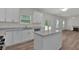 Contemporary kitchen with light countertops, island, and modern appliances open to the living area at 4401 Belcamp Rd, Union City, GA 30213