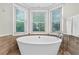 Luxurious bathroom with a freestanding tub, wood-look tile, and modern fixtures at 5037 Laurel Springs Se Way, Smyrna, GA 30082