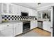 Well-lit kitchen with white cabinets, stainless steel appliances, and black-and-white tiled backsplash at 5037 Laurel Springs Se Way, Smyrna, GA 30082