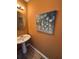 Cozy half bathroom with a pedestal sink, wood look floors and modern light fixture at 6231 Redan Overlook, Lithonia, GA 30058