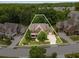 Aerial view of a brick home with a well-manicured lawn, lush trees, and outlined property at 5830 Caveat Ct, Suwanee, GA 30024