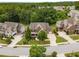 Aerial view of a brick home with a well-manicured lawn, lush trees, and a surrounding neighborhood at 5830 Caveat Ct, Suwanee, GA 30024