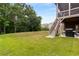 Expansive backyard featuring lush green grass, surrounding trees, and access to the patio at 5830 Caveat Ct, Suwanee, GA 30024