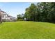 Large backyard featuring lush green grass, mature trees, and play set at 5830 Caveat Ct, Suwanee, GA 30024