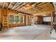 Unfinished basement with exposed ceiling beams, a large window, and a gray rug on a concrete floor at 5830 Caveat Ct, Suwanee, GA 30024