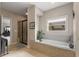 Relaxing bathroom featuring a soaking tub, glass shower, and bright window, perfect for unwinding at 5830 Caveat Ct, Suwanee, GA 30024