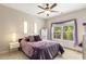Cozy bedroom with ceiling fan and a large window view overlooking lush trees at 5830 Caveat Ct, Suwanee, GA 30024
