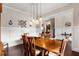 A dining room with hardwood floors features a wood table with seating for six with modern lighting at 5830 Caveat Ct, Suwanee, GA 30024