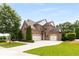 Charming brick home with manicured lawn, attached two-car garage, and mature trees at 5830 Caveat Ct, Suwanee, GA 30024
