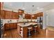 A modern kitchen features an island with granite countertops, stainless steel appliances, and hardwood floors at 5830 Caveat Ct, Suwanee, GA 30024