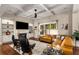 Bright living room with built-in shelving, a fireplace, hardwood floors, and large windows overlooking the yard at 5830 Caveat Ct, Suwanee, GA 30024