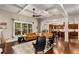A spacious living room shows a coffered ceiling, hardwood floors, and connects to an open concept kitchen at 5830 Caveat Ct, Suwanee, GA 30024