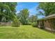 Expansive backyard featuring a well-maintained lawn, mature trees, and a classic brick home exterior at 4653 Ridgewood Dr, Forest Park, GA 30297