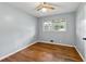 Bedroom with hardwood floors, a ceiling fan, and a large window providing ample natural light at 4653 Ridgewood Dr, Forest Park, GA 30297