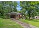 Classic brick home with an attached carport, mature trees, and a well-maintained front yard at 4653 Ridgewood Dr, Forest Park, GA 30297