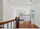 Upstairs hallway featuring hardwood floors, white trim, and a decorative window with a chandelier at 5615 Toccoa Dr, Douglasville, GA 30135