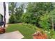 Large grassy backyard featuring mature trees and landscaped garden beds at 1380 Wayne Ne Ave, Atlanta, GA 30306
