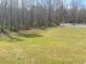 Open grassy backyard with trees and a white fence in the background at 2517 Oak Valley Ln, Dacula, GA 30019