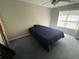 Bedroom featuring a dark blue bed, carpeted floors, and a window for natural light at 2517 Oak Valley Ln, Dacula, GA 30019