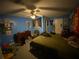 A blue bedroom with a ceiling fan, black tapestry, and various items on the dresser at 2517 Oak Valley Ln, Dacula, GA 30019