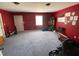 Large living room with a red accent wall, carpeted floors, and natural light, perfect for entertaining at 2517 Oak Valley Ln, Dacula, GA 30019