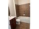 Bathroom features a combination shower and tub, and brown tiled walls and floors at 5669 Avonley Creek Dr, Sugar Hill, GA 30518