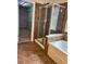 A tiled bathroom featuring a glass shower and a soaking tub at 5669 Avonley Creek Dr, Sugar Hill, GA 30518