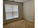 A carpeted bedroom featuring a window and neutral-painted walls at 5669 Avonley Creek Dr, Sugar Hill, GA 30518