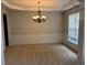 Elegant dining room with modern chandelier, chair rail and wainscotting at 5669 Avonley Creek Dr, Sugar Hill, GA 30518