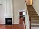Staircase near the fireplace with hardwood floors and carpeted steps at 5669 Avonley Creek Dr, Sugar Hill, GA 30518