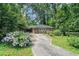 Charming single-story brick home with a covered parking area and a driveway lined with flowers at 2875 Monterey Dr, Decatur, GA 30032