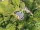 Aerial view of a charming home nestled among lush trees, featuring a private backyard deck and a driveway at 2958 Paul Harris Rd, Dallas, GA 30157
