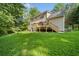 Spacious backyard with a two-story house, grassy lawn, and wooden deck with stairs at 2958 Paul Harris Rd, Dallas, GA 30157