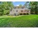 Large backyard with a two-story home, wooden deck, and mature trees at 2958 Paul Harris Rd, Dallas, GA 30157