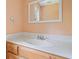 Bathroom vanity featuring a solid surface top, wood cabinetry, decorative mirror, and stylish fixtures at 2958 Paul Harris Rd, Dallas, GA 30157