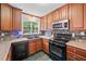 Kitchen featuring dark appliances, custom cabinetry, stone backsplash, and updated countertops at 2958 Paul Harris Rd, Dallas, GA 30157