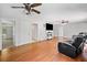 Spacious living room featuring hardwood floors, multiple ceiling fans, and a fireplace with a TV at 2958 Paul Harris Rd, Dallas, GA 30157