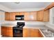 Kitchen with wood cabinets, sleek countertops, and modern black appliances at 6344 Wellington Walk Way, Lithonia, GA 30058
