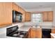 Efficient kitchen with oak cabinets, neutral countertops, and modern appliances at 6344 Wellington Walk Way, Lithonia, GA 30058