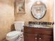 Powder room featuring dark wood cabinets, granite countertop, a decorative mirror, and warm paint colors at 7660 Treeridge Ct, Atlanta, GA 30350