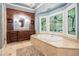 Luxurious bathroom with a jacuzzi tub, stained glass windows, and elegant cabinetry at 7660 Treeridge Ct, Atlanta, GA 30350