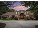A grand home featuring manicured landscaping, a circular driveway, and an arched front entrance at 7660 Treeridge Ct, Atlanta, GA 30350