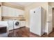 Well-equipped laundry room with a washer, dryer, sink, and built-in storage cabinets at 7660 Treeridge Ct, Atlanta, GA 30350