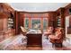 Wood-paneled office space featuring built-in bookcases, a large window, and ornate decor at 7660 Treeridge Ct, Atlanta, GA 30350