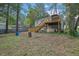 Backyard view featuring a deck, stairs, and mature trees, enhancing the property's outdoor appeal at 1377 Tucker Woods Dr, Norcross, GA 30093